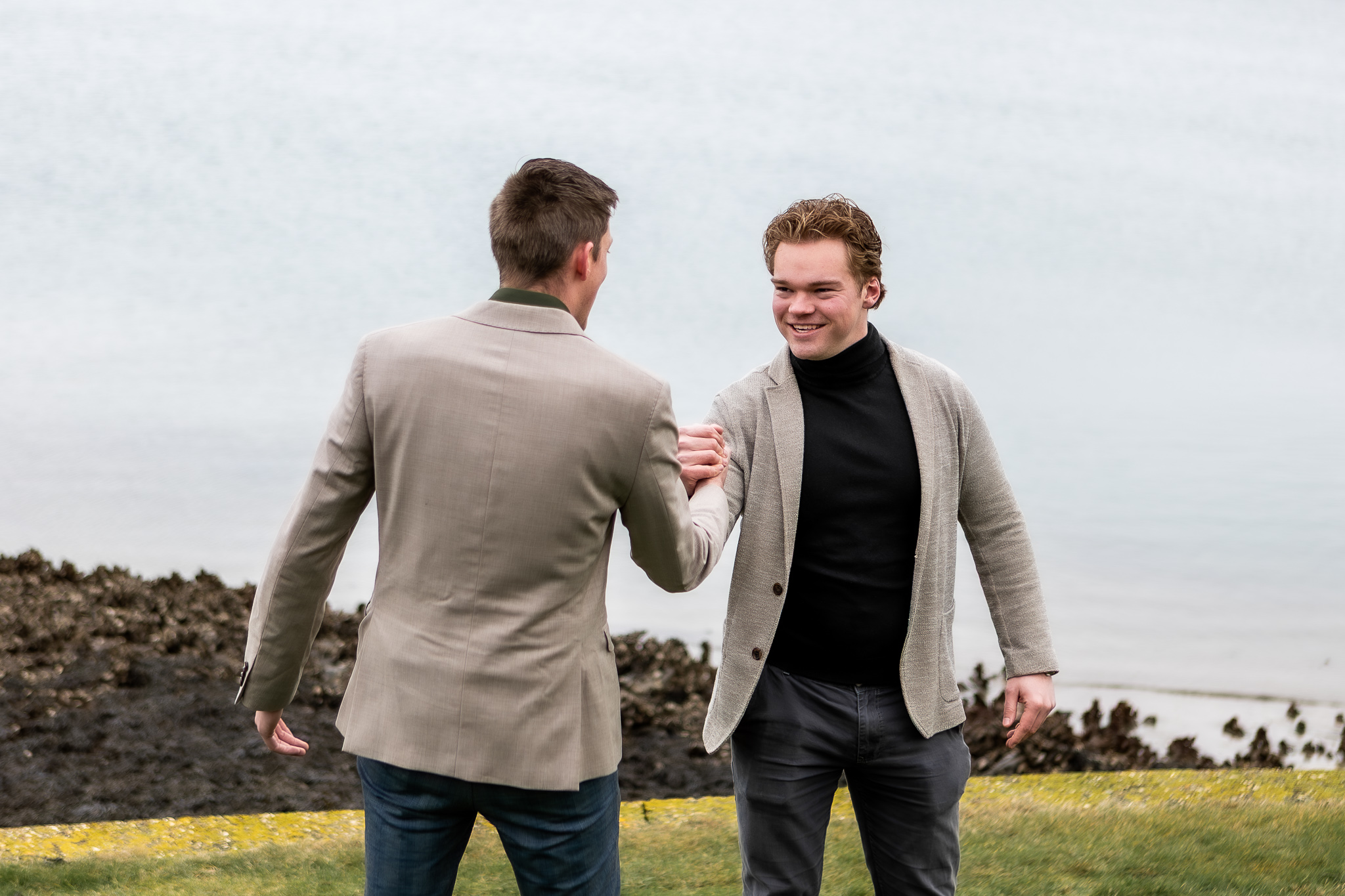 Twee medewerkers van Systeco tijdens een brandingfotoshoot aan het water